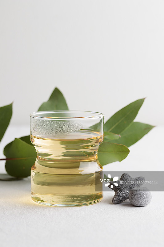 一杯新鲜的绿茶和甘草糖放在白色的桌子上图片素材