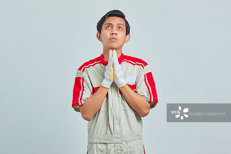 印度尼西亚，年轻英俊的机械师双手合十，一边祈祷一边恳求图片素材