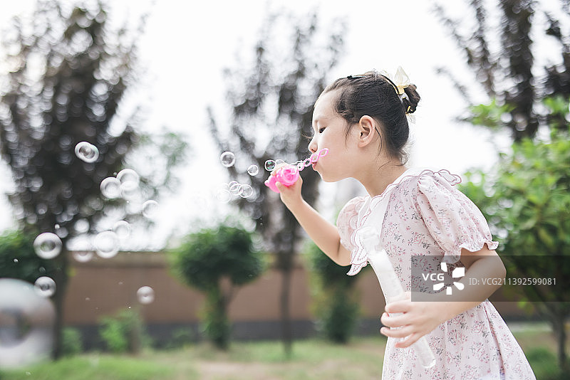 一个亚洲小女孩在吹泡泡图片素材