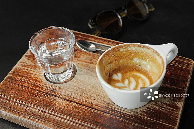 咖啡污渍在几乎空的白色咖啡杯在木板上图片素材