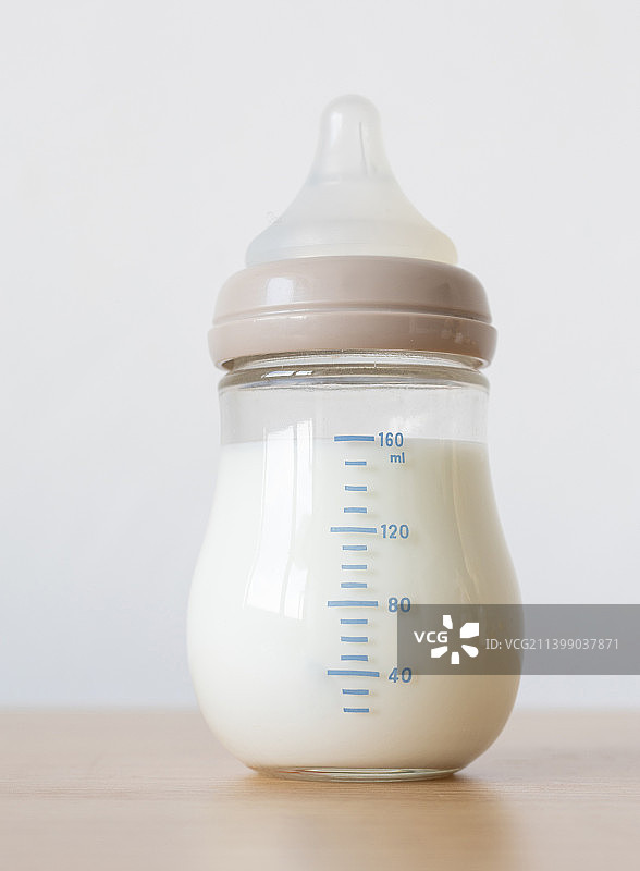 桌面上一个装满了奶的奶瓶图片素材