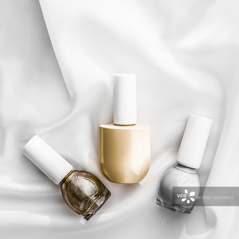 丝绸背景的指甲油瓶，法国美甲产品和图片素材