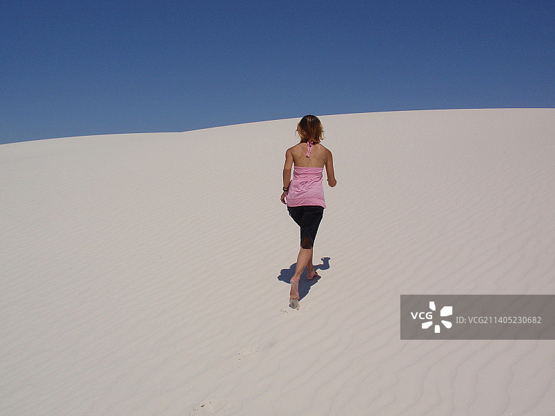 健身女性在白色沙丘上奔跑图片素材
