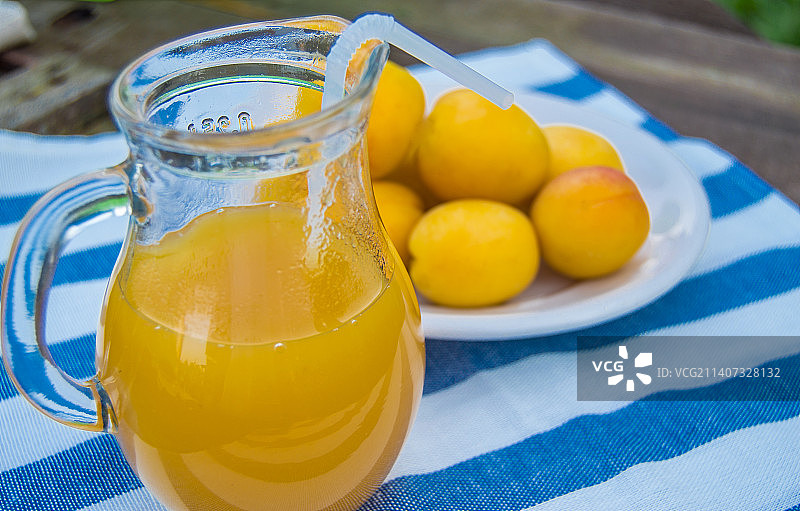 杏汁装在玻璃罐中，有吸管和餐巾上的水果图片素材