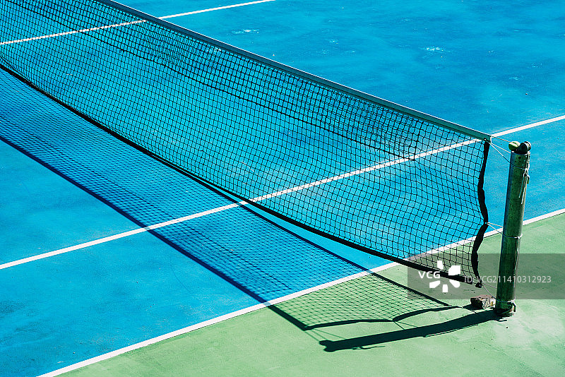 台湾，一个阳光明媚的夏日早晨，公园里一个废弃的网球场，背景是绿树图片素材