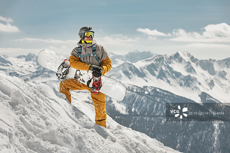 真正的滑雪板手拿滑雪板站在滑雪坡上图片素材