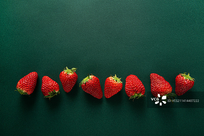 新鲜的草莓孤立在绿色背景上图片素材
