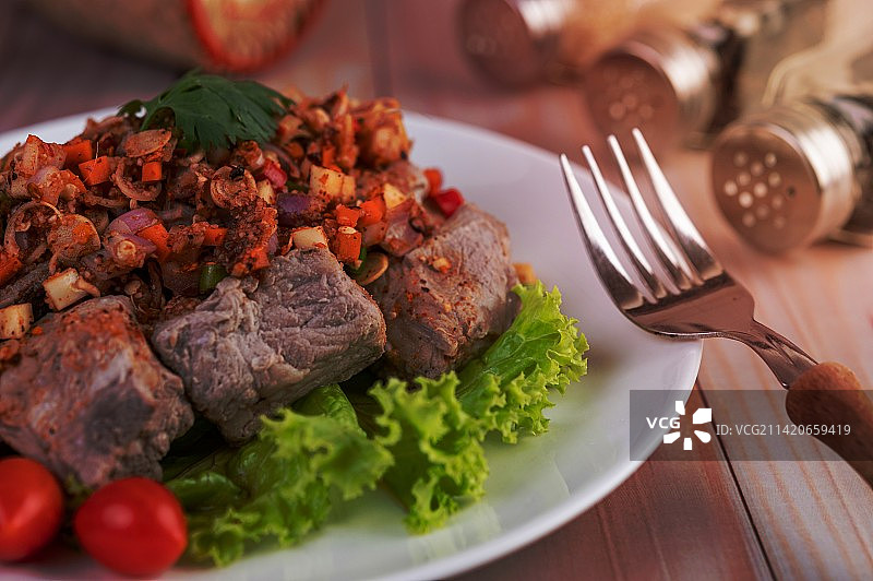 在罗马尼亚，木桌上的白色盘子里放着切碎的西红柿和生菜辣猪肉图片素材