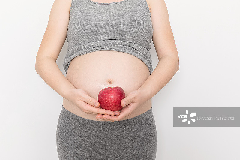 孕妇手拿着一只苹果图片素材