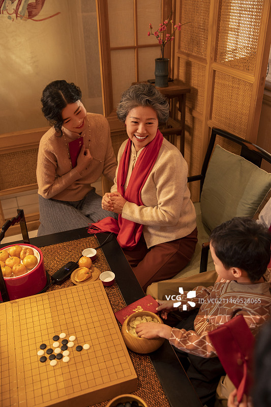 东方家庭过年：妈妈、奶奶和孩子在客厅拜年、送红包图片素材