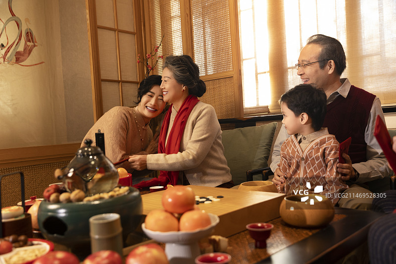 东方家庭过年：幸福一家人在客厅拜年、送压岁红包图片素材