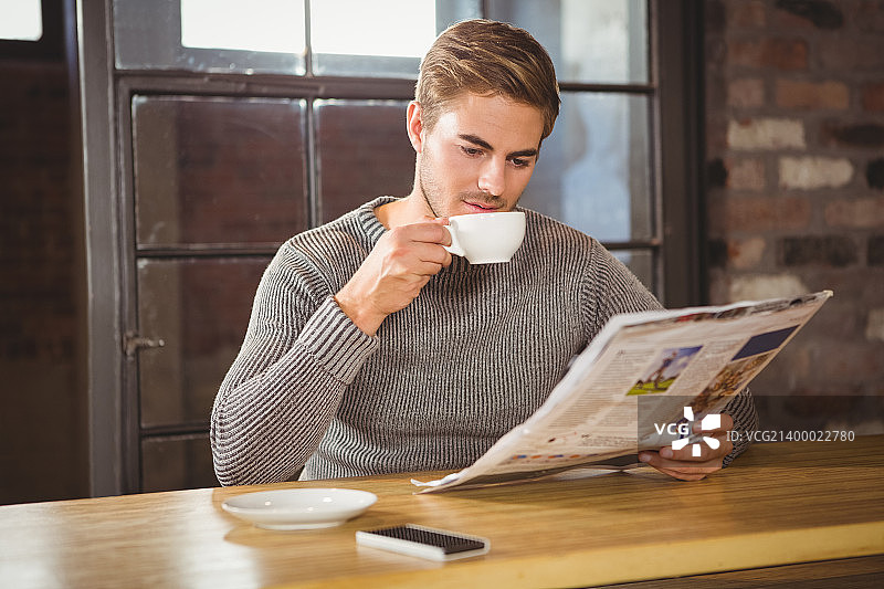 帅哥在咖啡店喝咖啡，看报纸图片素材
