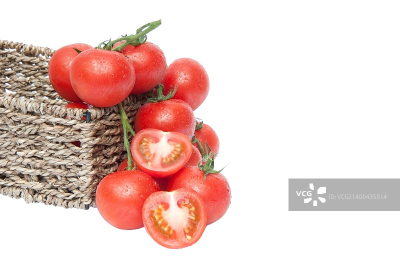 新鲜成熟的藤蕃茄在乡村篮子与切片蕃茄孤立在白色背景图片素材