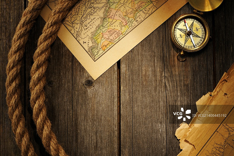 古董黄铜指南针和绳子在旧地图上图片素材