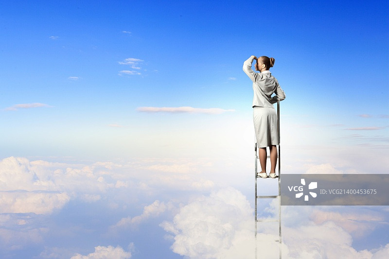 女商人站在梯子上望着远方，背对着阴云图片素材