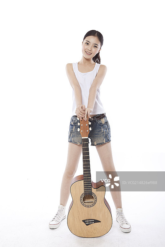 Young woman playing the guitar图片素材