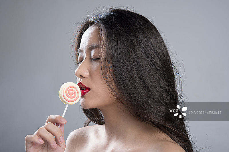 Young woman eating lollipop图片素材