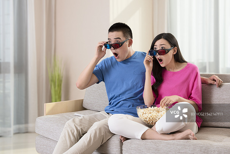 Young couple watching 3D TV图片素材
