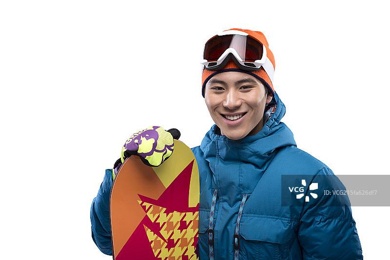 Portrait of a young man holding a snowboard looking at camera图片素材
