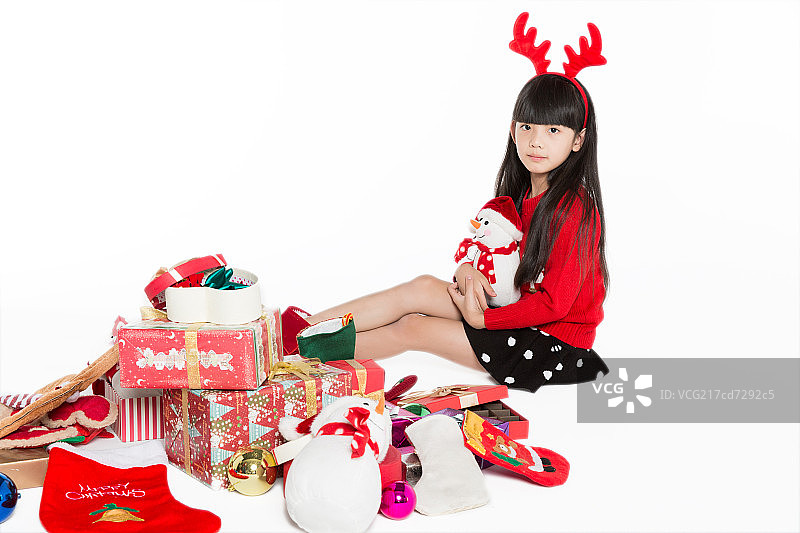 女孩坐在圣诞礼物旁边图片素材