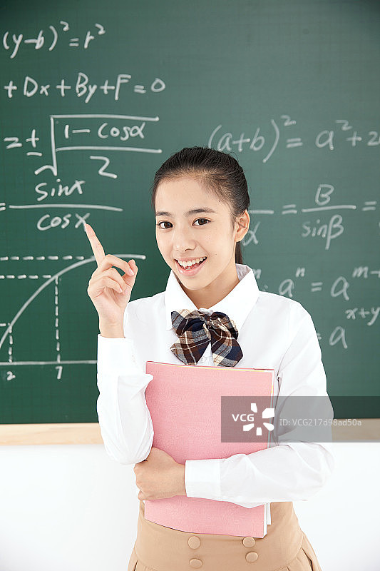 一个中学女生在教室里手指黑板图片素材