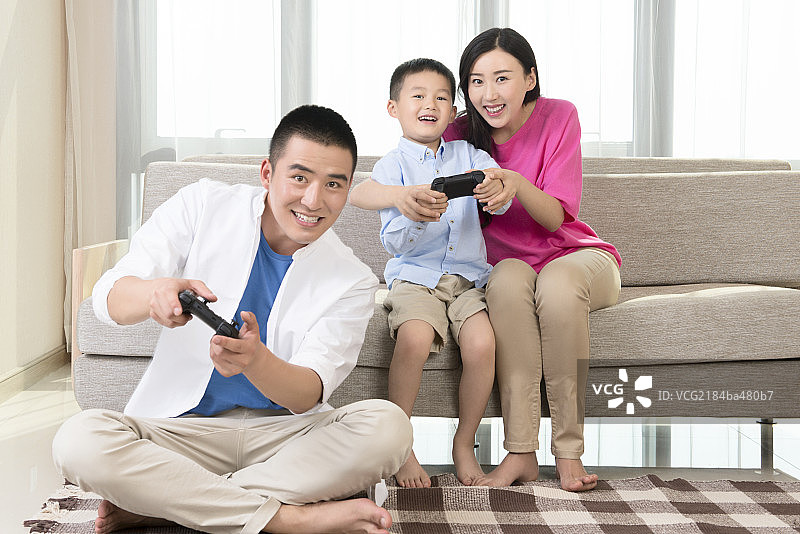 Young family playing video game图片素材