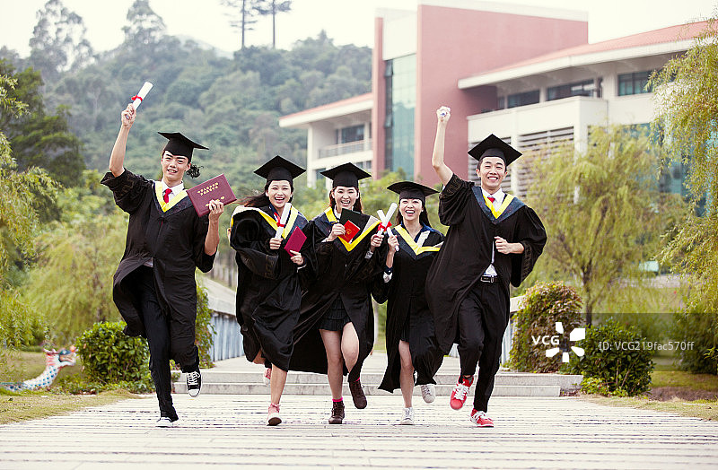 五个身穿学士服的大学生在校园奔跑图片素材