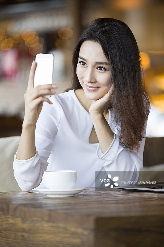 年轻女子在咖啡馆使用手机图片素材