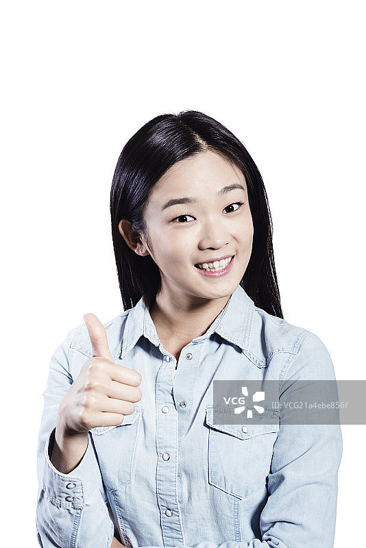 Portrait of young woman with thumb up图片素材