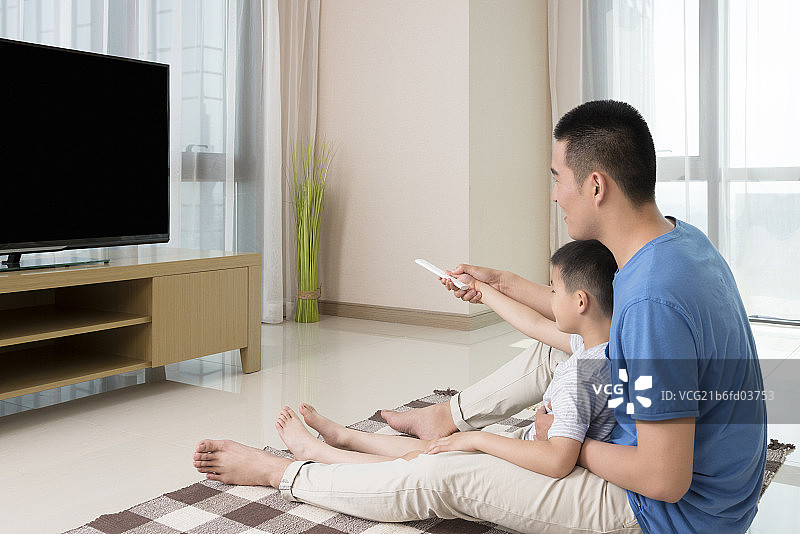 Father and son watching TV图片素材
