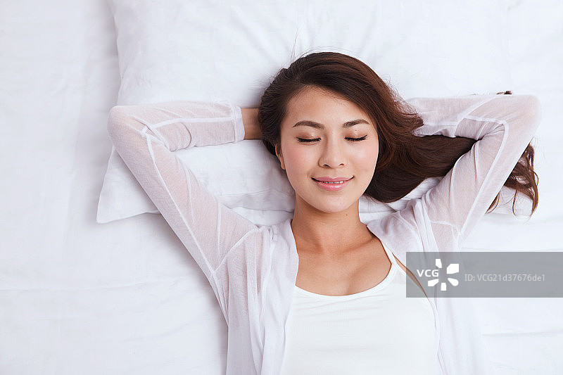 年轻女人躺在床上睡觉图片素材