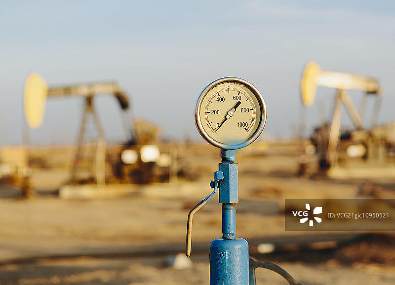 气压计，背景是石油钻塔，日落-中途油田，加州最大的油田。图片素材