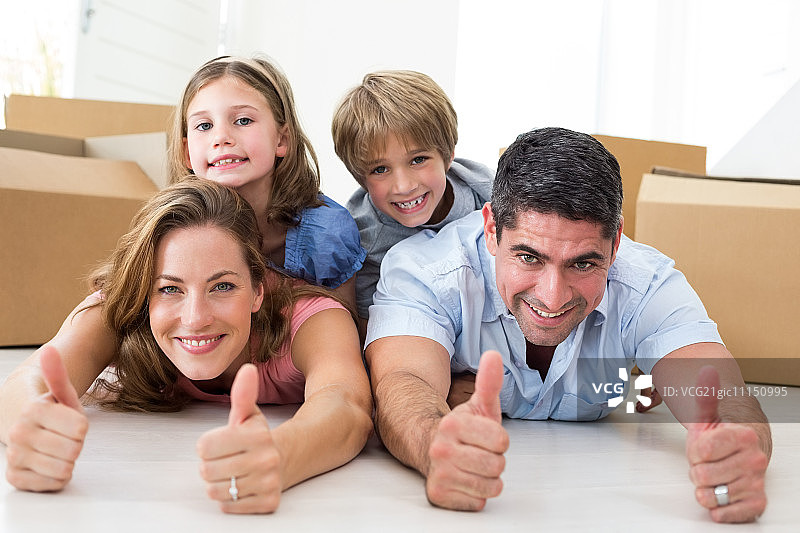 幸福家庭的肖像，在他们躺在新房子里竖起大拇指图片素材