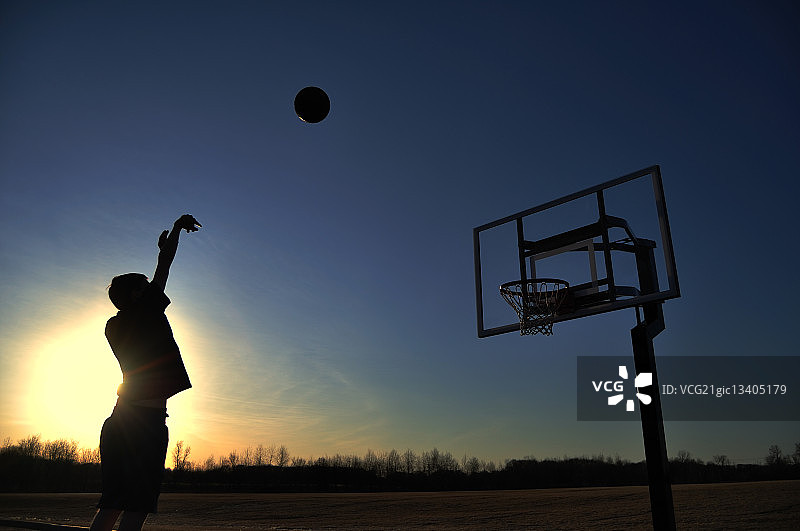 一个少年射击篮球的剪影图片素材