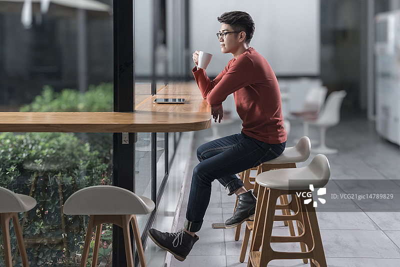 Creative businessman drinking coffee in break room图片素材