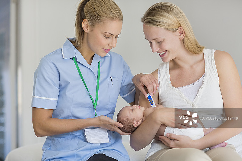 母亲和护士为新生儿量体温图片素材
