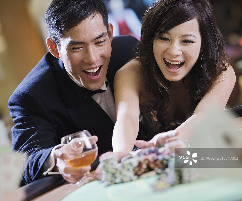 兴奋的年轻夫妇在赌场获胜图片素材