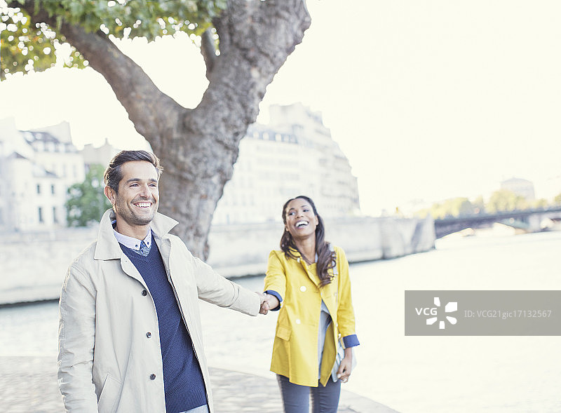 一对夫妇在法国巴黎塞纳河上牵着手图片素材