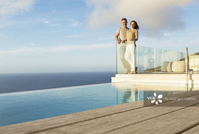 一对夫妇在现代化的阳台上俯瞰大海图片素材