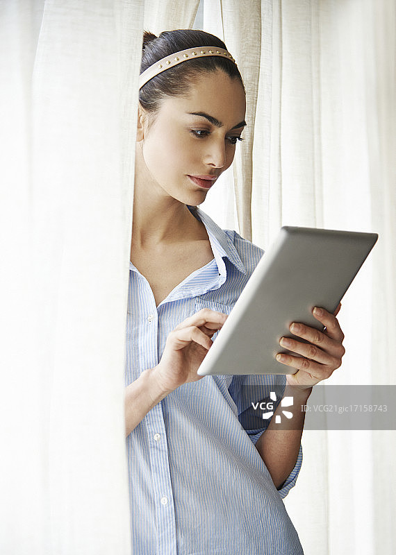 在窗口使用平板电脑的女人图片素材
