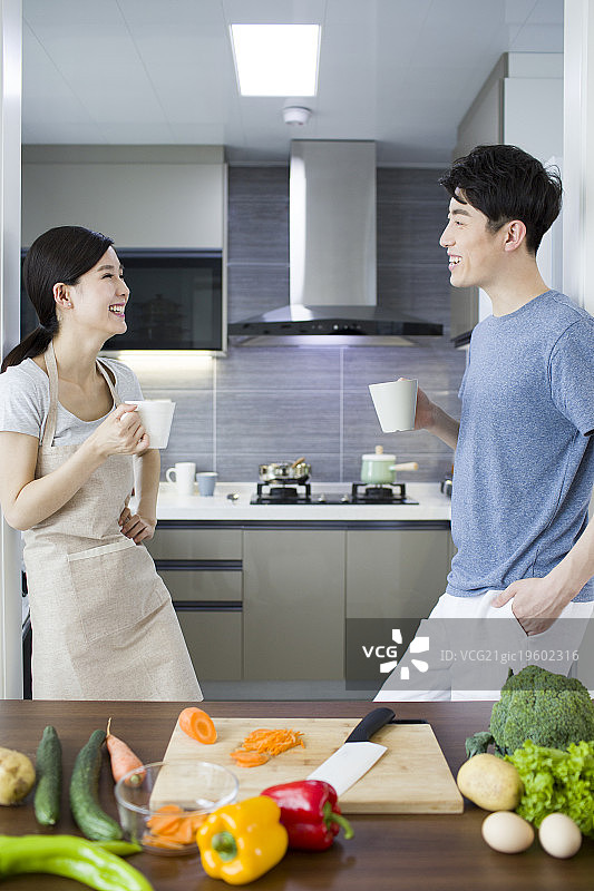 快乐的年轻夫妇在厨房喝咖啡图片素材