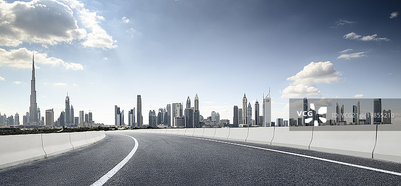 逆光下的迪拜摩天大楼建筑群和道路图片素材