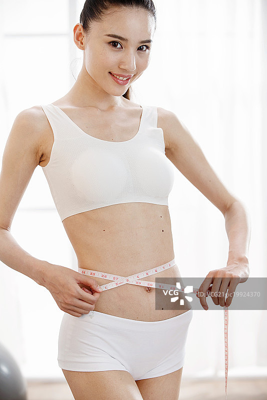青年女人测量腰围图片素材