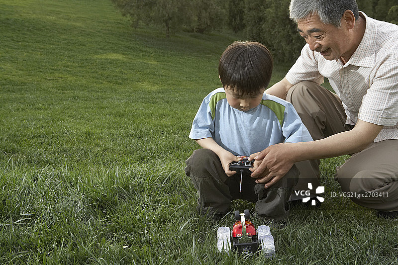 老人和小男孩玩遥控车图片素材