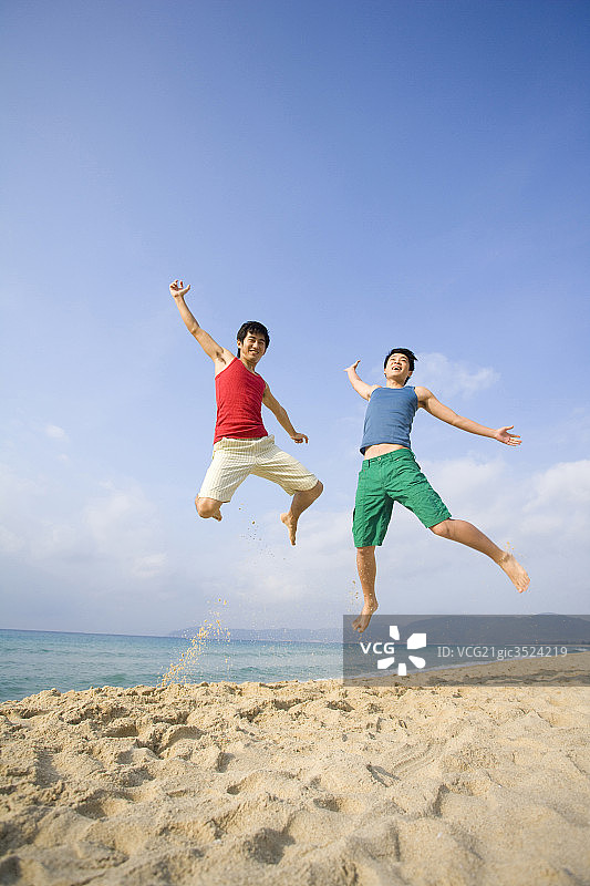年轻人在沙滩上跳图片素材