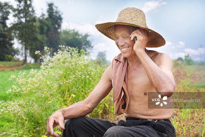 农民在田间用手机打电话图片素材