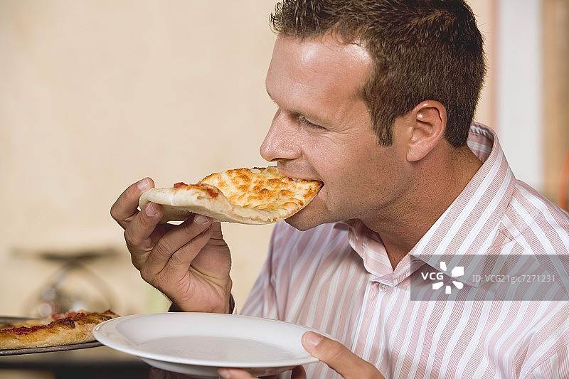 一个男人咬着一块披萨图片素材