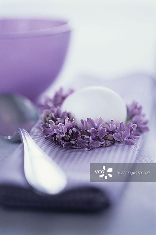 紫色的布餐巾，丁香花环和白色的鸡蛋图片素材