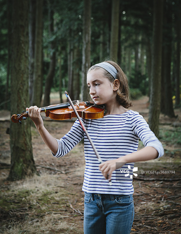 一个十岁的女孩在西雅图的探索公园拉小提琴。图片素材