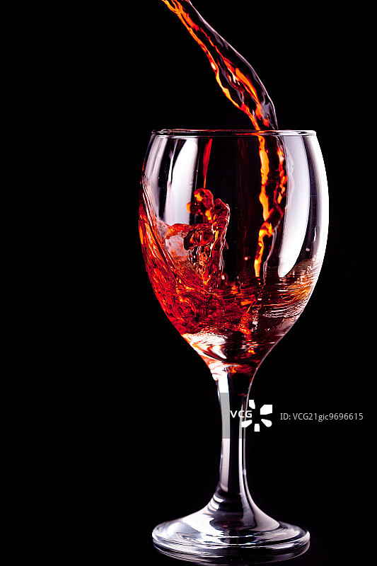 黑色背景下的空酒杯里装满了葡萄酒图片素材